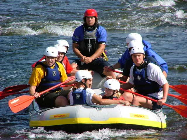 Team in einem Schlauchboot beim Rafting auf einem Fluss